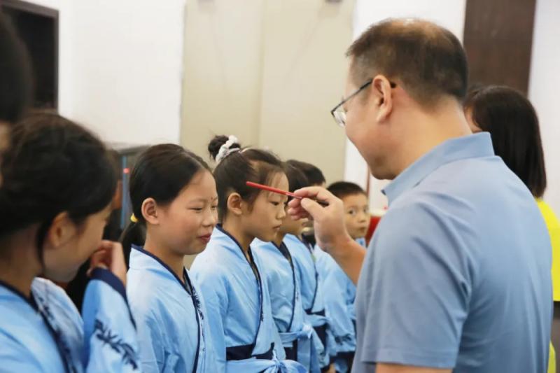 李建华和吴明元用毛笔和朱砂在萌娃们额头点上朱砂痣.jpg