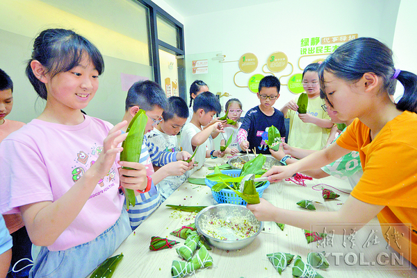孩子们围在一起包粽子。